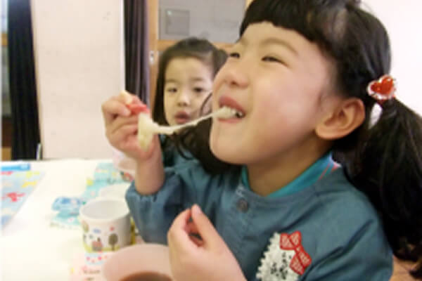 お餅を食べる子どもの写真